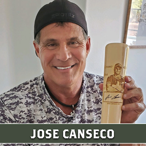 Jose Canseco smiling and holding a wooden Dugout Mugs baseball bat mug engraved with a portrait.
