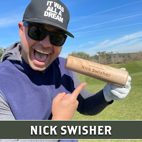 Nick Swisher smiling outdoors and pointing to a wooden Dugout Mugs baseball bat mug.