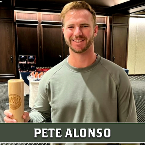 Pete Alonso smiling and holding a wooden Dugout Mugs baseball bat mug.